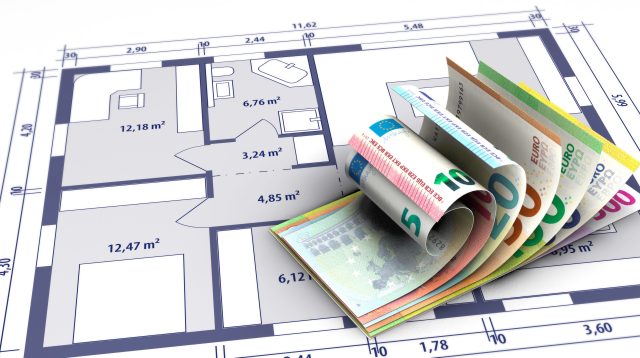 Geldscheine liegen auf einem Bauplan