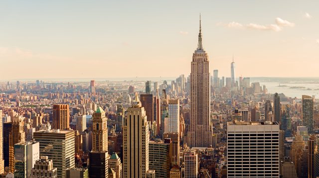 Manhattan Midtown Skyline mit beleuchteten Wolkenkratzern bei Sonnenuntergang in NYC, USA