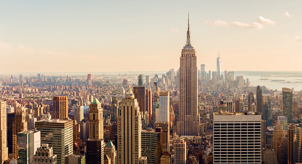 Manhattan Midtown Skyline mit beleuchteten Wolkenkratzern bei Sonnenuntergang in NYC, USA