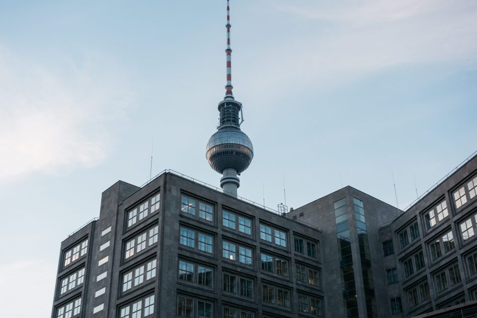 Fernsehturm in Berlin mit Bürogebäude im Vordergrund