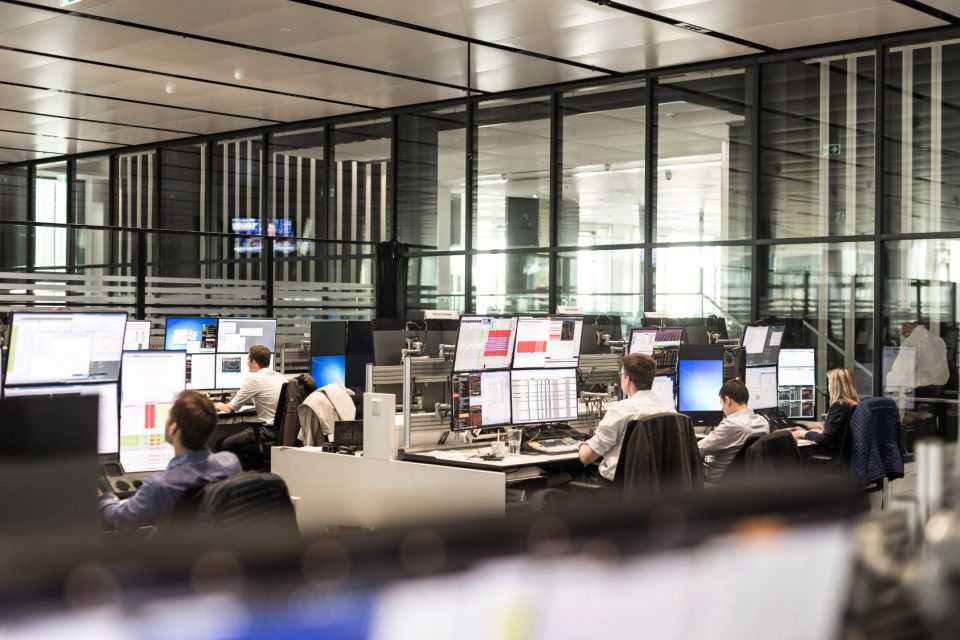 Der Handelssaal der Deutschen Bank. Zahlreiche Menschen sitzen an Computern mit vielen Bildschirmen.