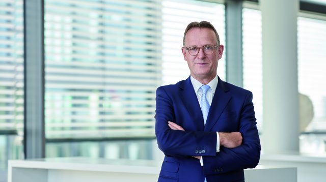 Ralf Lochmüller im blauen Anzug mit verschränkten Armen.