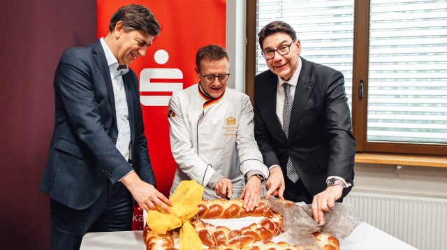 Roman Frank, Claus Becker und Thomas Hirsch präsentieren die traditionelle Neujahrsbrezel, die Glück, Gesundheit und Wohlstand bringen soll.