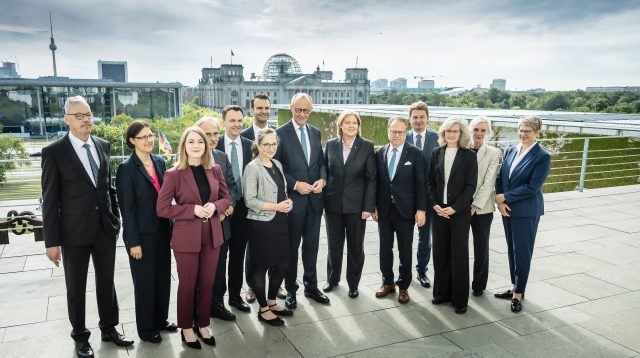 Bundeskanzler Friedrich Merz (M.) mit Bärbel Bas, Bundesministerin für Arbeit und Soziales (6.v.r.) und den Mitgliedern der Alterssicherungskommission.