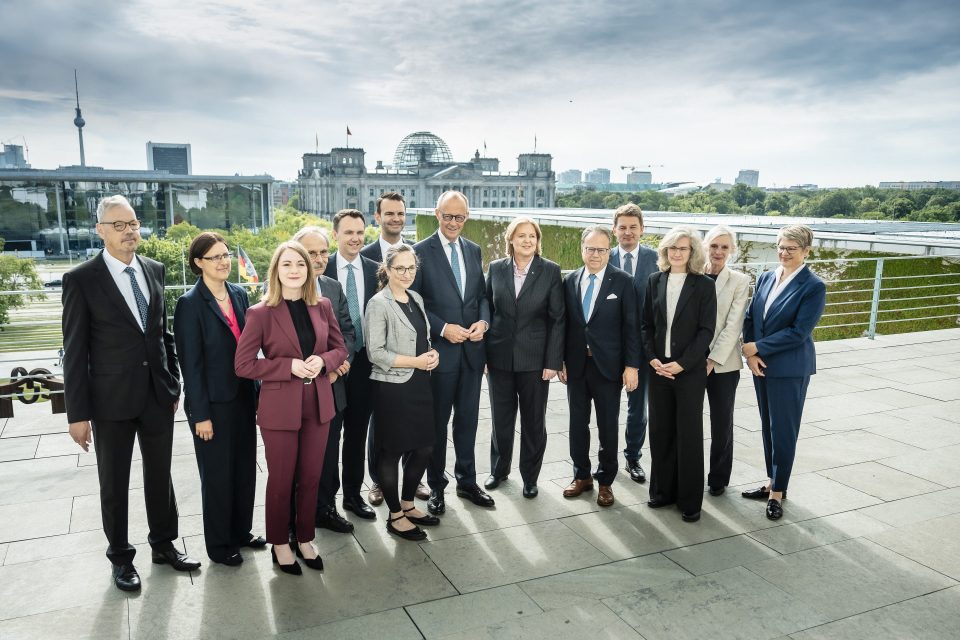 Bundeskanzler Friedrich Merz (M.) mit Bärbel Bas, Bundesministerin für Arbeit und Soziales (6.v.r.) und den Mitgliedern der Alterssicherungskommission.