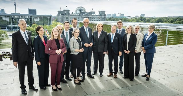 Bundeskanzler Friedrich Merz (M.) mit Bärbel Bas, Bundesministerin für Arbeit und Soziales (6.v.r.) und den Mitgliedern der Alterssicherungskommission.